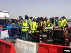 Aid workers distribute food to crowds of people camping on Piraeus port, many who have been there for a month, hoping the Macedonia border will open despite the fact that Macedonia continues to grow its border patrols, Athens, Greece, April 8, 2016. (H. M