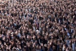 People raise their hands to condemn a suicide attack on Shi'ite mourners during a funeral in Rawalpindi, Pakistan, November 22, 2012.