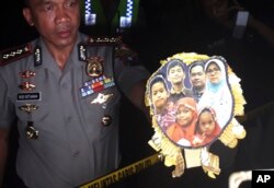 FILE - Surabaya Police Chief Col. Rudi Setiawan shows a picture of the family of Dita Oepriarto who carried out the church attacks on May 13, 2018 in Surabaya, East Java, Indonesia.