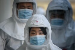 In this photo taken on March 12, 2020, medical workers wearing protective clothing against the COVID-19 novel coronavirus walk to a decontamination area at the Keimyung University hospital in Daegu. - South Korea.