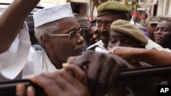 Former Chad dictator Hissène Habré, left, seen as he leaves the court in Dakar, Senegal, Nov. 25, 2005.