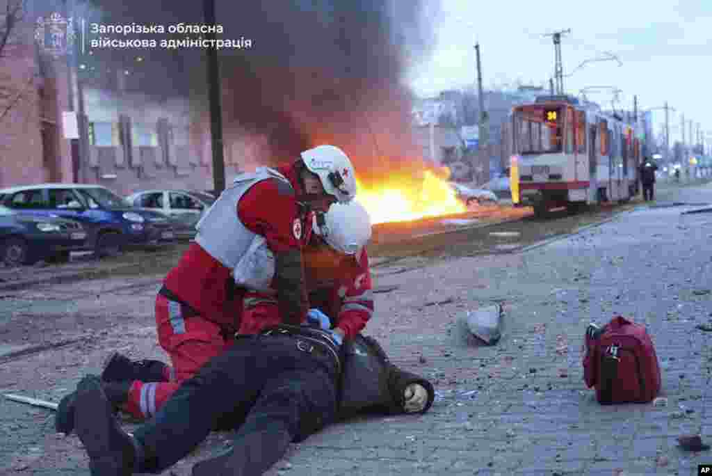 In this photo provided by the Zaporizhzhia regional military administration, paramedics work to resuscitate a man injured in a Russian airstrike in Zaporizhzhia, Ukraine.