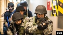 FILE - Team members from the Indian and U.S. navies take part in a joint training exercise aboard an Indian ship in June 2016.