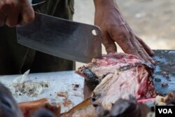 ម្ចាស់​ហាង​សាច់​ឆ្កែ​មួយ​កន្លែង​ក្នុង​សង្កាត់​ភ្នំពេញ​ថ្មី​កំពុង​កាត់​សាច់​ឆ្កែ​ដើម្បី​អាំង​ឲ្យ​អតិថិជន។ (នៅ វណ្ណារិន/VOA)