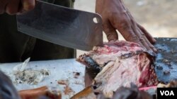 A shop owner seen here is preparing grilled dog meat for his customers. 