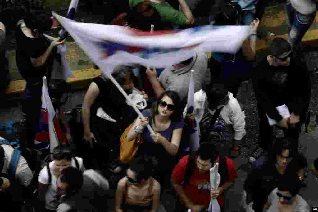 A member of pro-communist union PAME waves a flag outside the Greek state television ERT headquarters during a general strike in Athens, June 13, 2013.