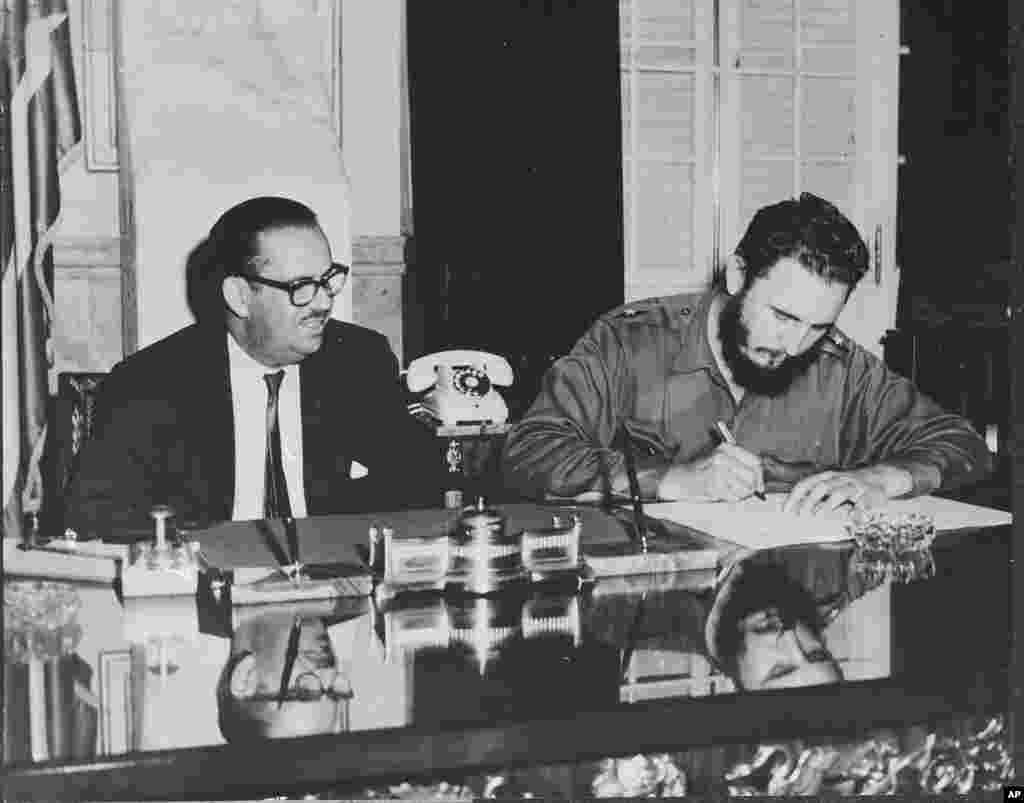 Perdana Menteri Kuba Fidel Castro menandatangani dekrit nasionalisasi semua bank milik Amerika Serikat di Kuba, 17 September 1960.&nbsp;