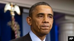 President Barack Obama pauses as he speaks about the death of Nelson Mandela in the briefing room of the White House, Dec. 5, 2013.