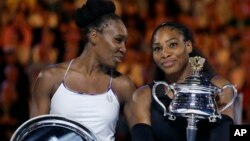  United States' Serena Williams, right, holds her trophy after defeating her sister Venus, left, during the women's singles final at the Australian Open tennis championships in Melbourne, Australia, Jan. 28, 2017.