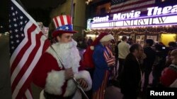 지난 24일 밤 미국 로스엔젤레스의 한 극장에서 개봉한 영화 '인터뷰'를 보기 위해 모인 관객들. 산타클로스 복장에 미국 국기를 든 관객도 보인다.