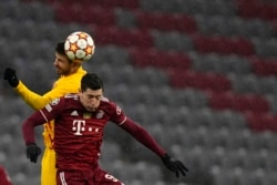 Dan wasan Bayern Robert Lewandowski, na gaba, da Gerard Pique na Barcelona sun tsallake rijiya da baya yayin wasan kwallon kafa na gasar zakarun Turai a rukunin E tsakanin Bayern Munich da FC Barcelona a Munich, Jamus, Laraba, 8 ga Disamba, 2021. (AP Phot