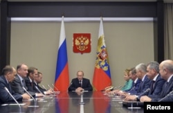 Russian President Vladimir Putin, center, meets with Security Council members at the Novo-Ogaryovo state residence outside Moscow, Sept. 30, 2015.