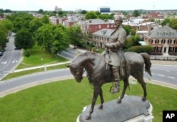 FILE - The statue of Confederate Gen. Robert E. Lee stands in the middle of a traffic circle on Monument Avenue in Richmond, Virginia.