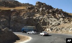 Vehicles take a sharp turn on a troubled highway near Pol-I-Kumari, Afghanistan, along the one time Silk Road route. Growing Taliban influence in northern Afghanistan is threatening the new military supply line painstakingly negotiated by the U.S.,