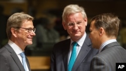 German Foreign Minister Guido Westerwelle (left) talks with Swedish Foreign Minister Carl Bildt (center) and Poland's Foreign Minister Radoslaw Sikorski during a European foreign ministers meeting in Luxembourg, June 24, 2013.