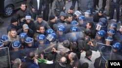 Para demonstran bentrok dengan polisi dalam demonstrasi kelompok oposisi di Aljiers, 22 Januari.