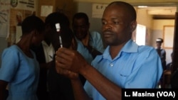 A medical worker at Likuni Community Hospital, in Lilongwe, Malawai draws the malaria vaccine into a syringe for vaccination.