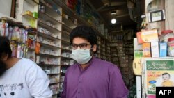 ឱសថការីម្នាក់ពាក់ម៉ាសការពារប្រឆាំងនឹងការរីករាលដាលវីរុសកូរ់ូណា នៅប្រទេសប៉ាគីស្ថាន កាលពីថ្ងៃទី២៧ ខែកុម្ភៈ ឆ្នាំ២០២០។ 