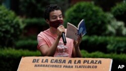 Percibald Garcia uses a microphone to read aloud children's stories amid the high-rise housing complex of Tlatelolco, in Mexico City, Saturday, July 18, 2020. 