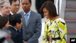 FILE - U.S. first lady Michelle Obama, right, is greeted by an unidentified Japanese official upon her arrival at Haneda International Airport in Tokyo, March 18, 2015. 