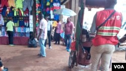 Un groupe de vendeurs au marché central à Yaoundé discutent sur la question de la longévité au pouvoir des présidents africains, Cameroun, le 22 novembre 2017. (VOA/Emmanuel Jules Ntap)