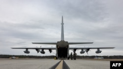 Marinir AS melakukan pemeriksaan pra-penerbangan pada KC-130J Super Hercules di Pangkalan Udara Korps Marinir Cherry Point, North Carolina, yang akan digunakan untuk mengangkut imigran tanpa dokumen ke Teluk Guantanamo. 