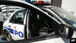 FILE - A New Orleans police officer leans against a patrol car, Sept. 11, 2005. 