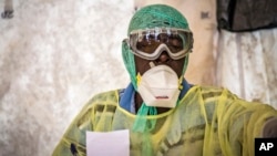 A health worker examines patients for Ebola inside a screening tent, at the Kenema Government Hospital about 300 km, (186 miles), from the capital city of Freetown in Kenema, Sierra Leone, Aug. 11, 2014. 