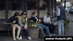 In this Wednesday, April 8, 2020 file photo youths hang out outside a restaurant in Stockholm, Sweden. (AP Photo/Andres Kudacki, File)