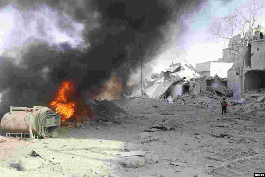 A boy stands on rubble at a site hit by what activists said was a barrel bomb dropped by forces loyal to Syria's President Bashar al-Assad in the al-Maadi neighborhood of Aleppo, June 20, 2014. 