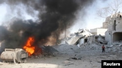 A boy stands on rubble at a site hit by what activists said was a barrel bomb dropped by forces loyal to Syria's President Bashar al-Assad in the al-Maadi neighborhood of Aleppo, June 20, 2014. 