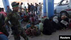 19일 이라크 시아파 민명대가 라마디 시의 수니파 난민들 곁을 지나고 있다.