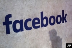 FILE - A Facebook logo is displayed at a start-up companies' gathering at Paris' Station F, in Paris, France, Jan. 17, 2017.
