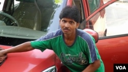 Jay Prakash Mahato terlihat membersihkan mobil, salah satu dari tiga pekerjannya, di distrik bisnis Gurgaon yang sibuk di New Delhi. (VOA/Anjana Pasricha).