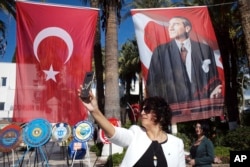 Photo taken on Oct. 28, 2018 shows a Turkish womPhoto taken on Oct. 28, 2018 shows a Turkish woman taking a selfie in front of a poster of Mustafa Kemal Ataturk, Turkey's founder, in Bodrum, Turkey, a day before thousands of army officers, soldiers, teachers, politicians, including Turkey's President Recep Tayyip Erdogan visit his mausoleum on Republic Day in Ankara.