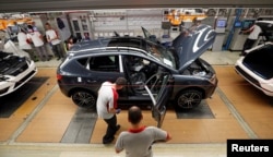 Workers put together vehicles on the assembly line of the SEAT car factory in Martorell, near Barcelona, Spain, Oct. 31, 2018.