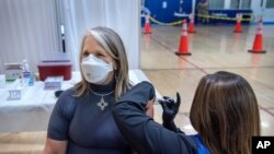 New Mexico Governor Michelle Lujan Grisham receives her Pfizer COVID-19 vaccine from Deanne Tapia, a registered nurse with the New Mexico Public Health Office in Santa Fe, at a vaccination event in Santa Fe, N.M., March 26, 2021.