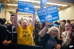 FILE - Supporters celebrate news that Democrat Ralph Northam won the gubernatorial election, at the Northam for Governor election night party at George Mason University in Fairfax, Va., Nov. 7, 2017.