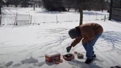 A man tries to keep his food fresh by putting it on snow as his fridge does not function following power outage in Temple, Texas