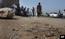 Pakistani police officers and local residents gather at the site of a firing incident at Garhi Sohbat Khan on the outskirts of Peshawar, Pakistan, Sept. 18, 2016. Two gunmen on a motorcycle killed three soldiers Sunday, police said.