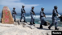FILE - Soldiers of China's People's Liberation Army (PLA) Navy patrol at Woody Island, in the Paracel Archipelago, which is known in China as the Xisha Islands, Jan. 29, 2016. 