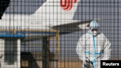 지난 6일 중국 베이징 공항에서 방역복을 입은 근무자들.