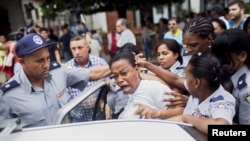 Cuban security personnel detain a member of the Ladies in White dissident group during a protest on International Human Rights Day, Havana, Dec.10, 2015.