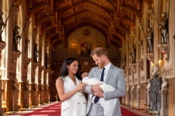 Pangeran Harry dari Inggris, Duke of Sussex (kanan), dan istrinya Meghan, Duchess of Sussex, berpose untuk foto bersama bayi laki-laki mereka yang baru lahir, Archie Harrison Mountbatten-Windsor. (Foto: AFP)
