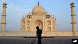 FILE - In this June 3, 2013, photo, a worker sweeps in front of Taj Mahal in Agra, India. India's Supreme Court has ordered a state government to remove a wood-burning crematorium from near the Taj Mahal to protect the iconic monument from pollution damag