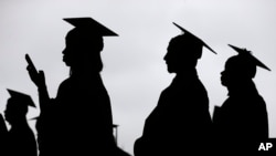 FILE - New graduates line up before the start of the Bergen Community College commencement at MetLife Stadium in East Rutherford, New Jersey, May 17, 2018.