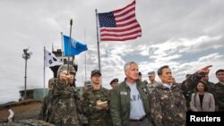 South Korean Defense Minister Kim Kwan-jin (R) points out a location in North Korea to U.S. Secretary of Defense Chuck Hagel, from Observation Point Ouellette during a tour of the Demilitarized Zone (DMZ), South Korea September 30, 2013. 