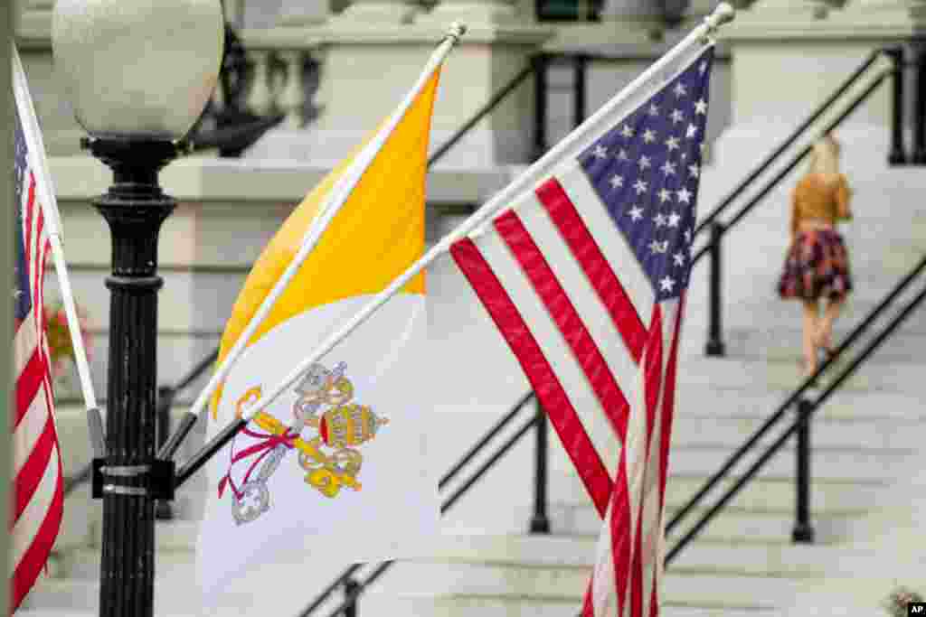 Bendera Vatikan City (Kepausan) berkibar di samping bendera Amerika sepanjang West Executive Avenue dekat Gedung Putih di Washington (21/9), sehari sebelum Paus Fransiskus tiba. (AP/Andrew Harnik)