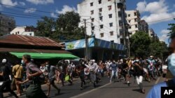 Pengunjuk rasa anti-kudeta berlari ketika mereka melihat tentara tiba untuk membubarkan demonstrasi mereka di Yangon, Myanmar pada Selasa 11 Mei 2021. (Foto: AP)