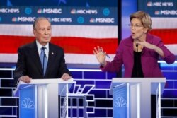 Democratic presidential candidates, former New York City Mayor Mike Bloomberg, left, listens as Sen. Elizabeth Warren, D-Mass., speak during a Democratic presidential primary debate, Feb. 19, 2020, in Las Vegas.